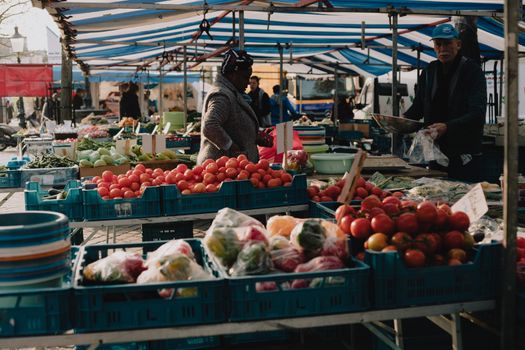 Weekmarkt Cuijk in het centrum met groente-, kaas- en bloemenkramen tussen winkelend publiek