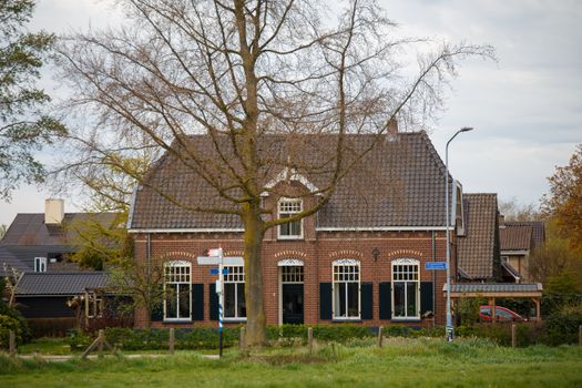 Straatbeeld in Cuijk met woningen, makelaarsborden en zicht op een rustige woonwijk
