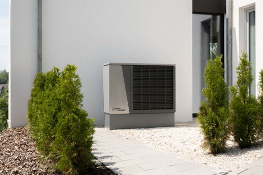 Monteur installeert een hybride warmtepomp bij een woning in Cuijk