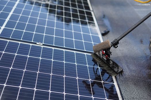 Huiseigenaar maakt zonnepanelen schoon op een woning in Cuijk met zachte borstel en water