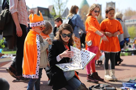 Oranje feestende mensen op een sfeervol Koningsdag festival in Cuijk met muziek, terrassen en vlaggen